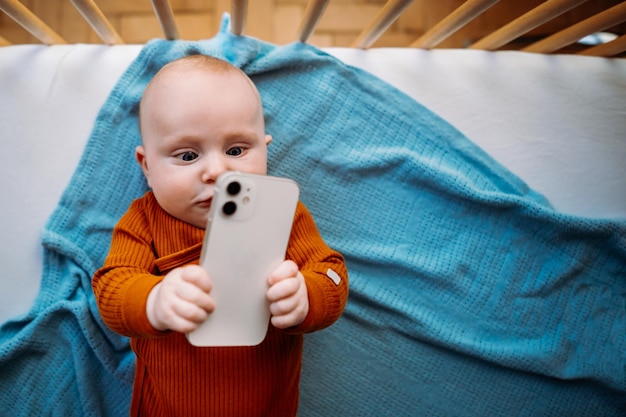 Baby peuter met smartphone Kopieer ruimte Grafisch concept Foto van hoge kwaliteit