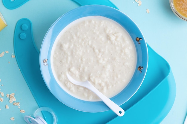 Baby plate with porridge on blue