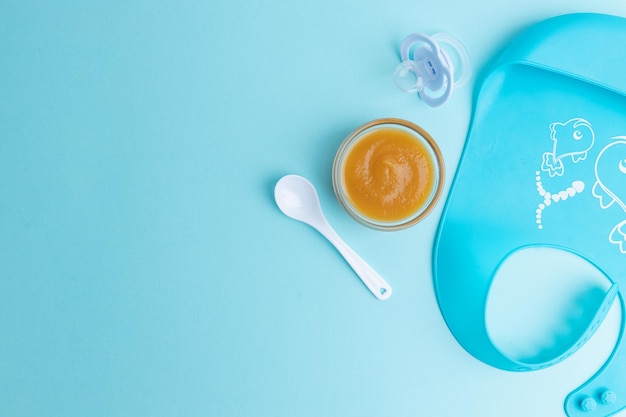 Photo baby plate with porridge on blue