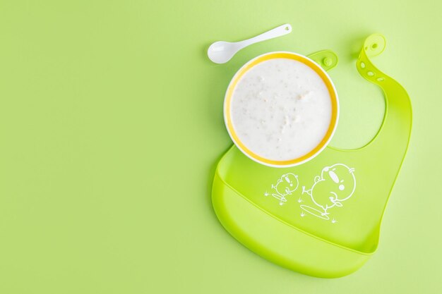 Baby plate with porridge on green