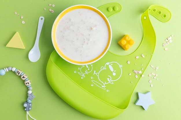 Baby plate with porridge on green