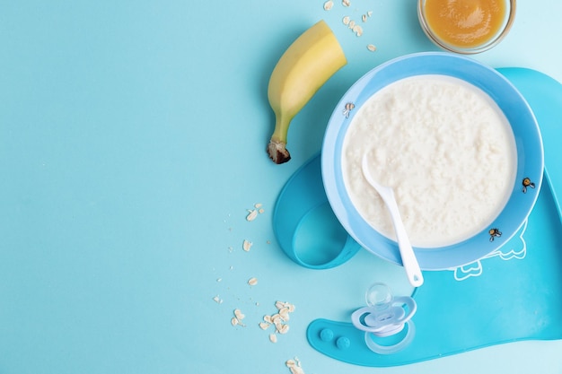 Photo baby plate with porridge on green