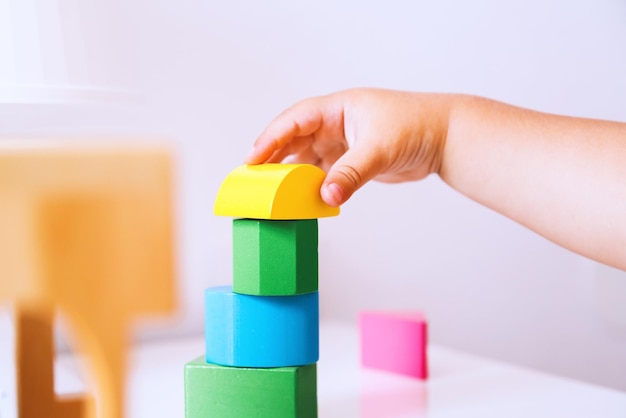 Baby playing and discovery with colorful toys at home Toddler plays with toy block and constructors