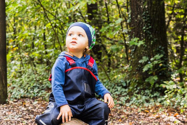 Bambino che gioca su un sentiero nel bosco in autunno