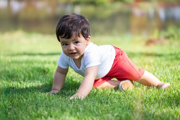 Bambino che gioca sull'erba in un parco.
