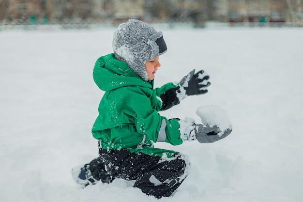 Фото Малыш играет в снежки снежные игры на свежем воздухе детские забавы игра baby39s лепит снеговика