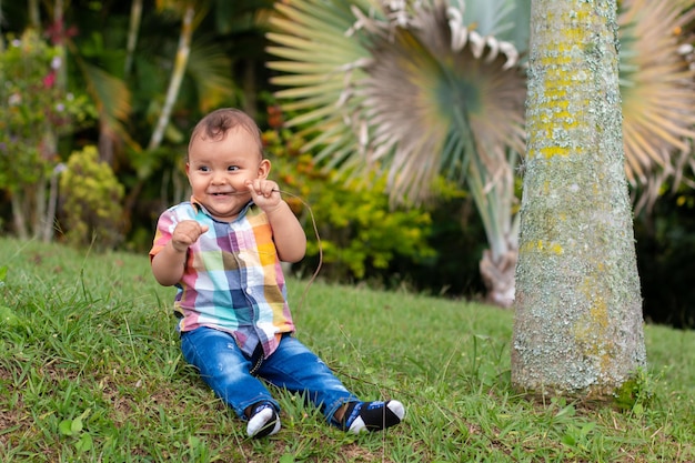 Baby playing on the lawn or in the garden full of nature