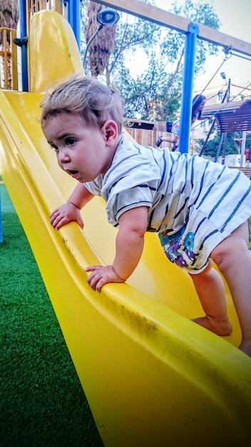 Baby playing on slide in playground