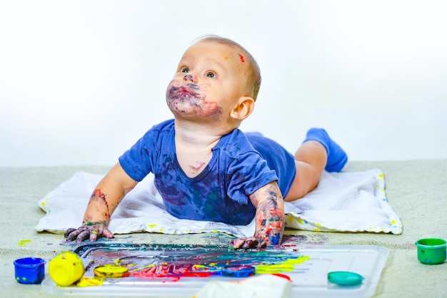 Baby playing with paints beautiful happy child lifestyle childhood concept little baby paint by his ...