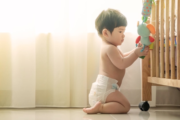 家の床でおもちゃで遊ぶ赤ちゃん