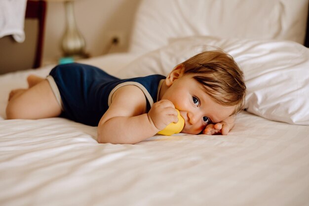 baby playing with toys in bed on white background