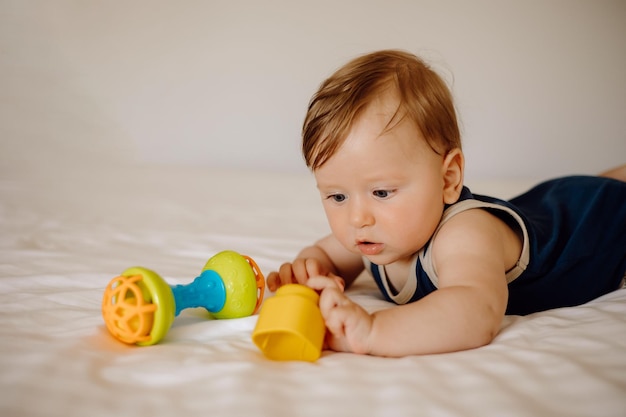 ребенок играет с игрушками в постели на белом фоне