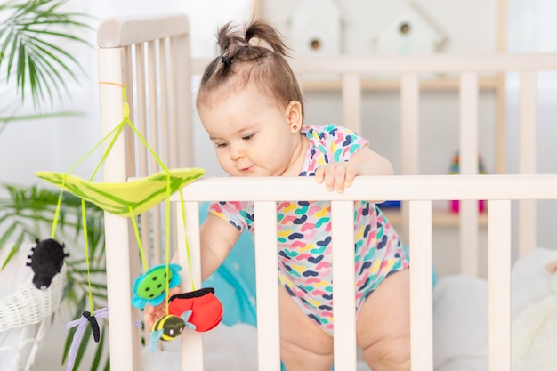 Baby plays mobile in crib at home, early development