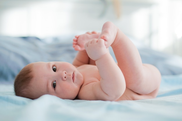 Foto il bambino gioca con i propri piedi