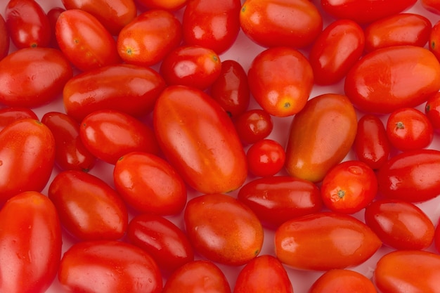 Baby plum tomatoes. textured. closeup. color red. isolated on white background