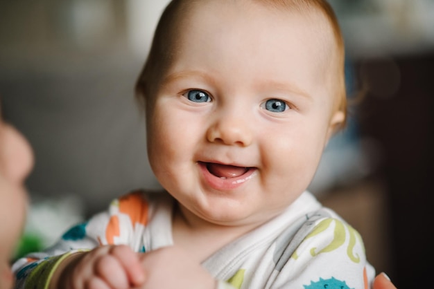 Baby portrait closeup face with bright blue eyes boy\
ophthalmology curiosity happiness exploring the world joy childhood\
psychology first teeth looking at the camera