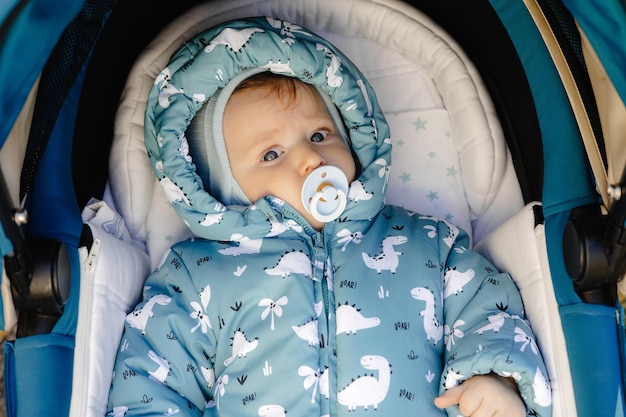 Baby portrait in a stroller with a pacifier