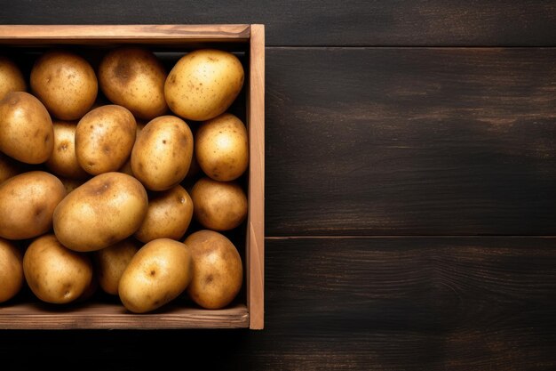 Baby potatoes round from india arranged in a wooden box on a black wooden table viewed from above