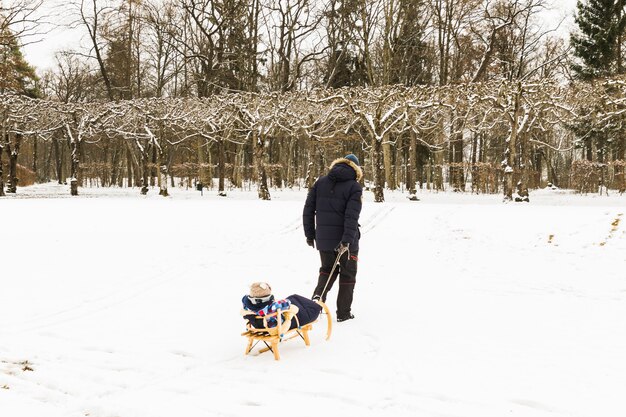 Baby rodelen op sneeuw in het bos