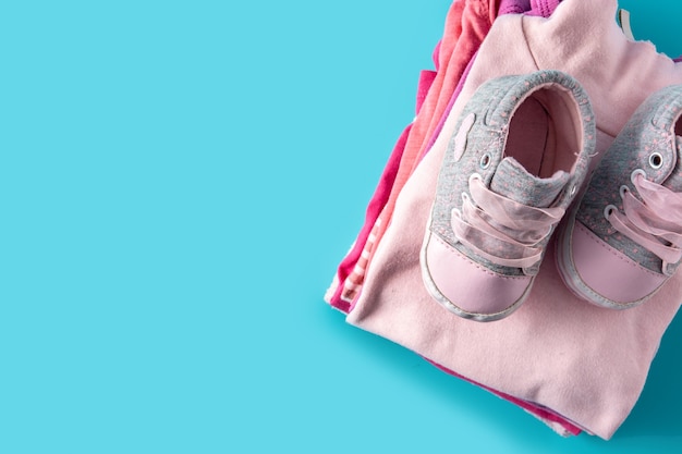 Baby rompers and baby shoes on blue background