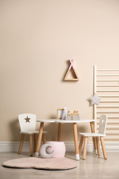 Photo baby room interior with stylish table chairs and toys