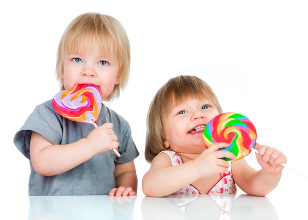 Baby's die een kleverige lolly op witte achtergrond eten