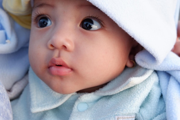 Photo baby's expression when held by her mother. she is a cute baby.