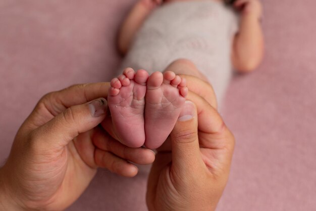 Foto i piedi di un bambino sono mostrati su uno sfondo rosa.