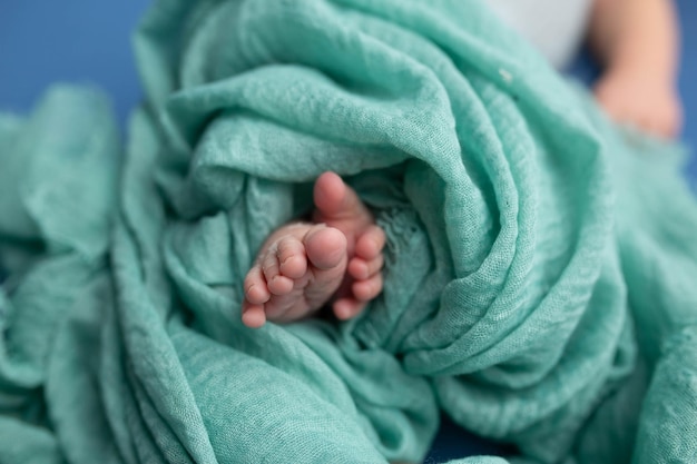 A baby's feet are wrapped in a blanket.