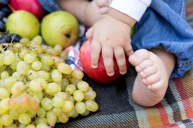 Детские ножки на одеяле с фруктами