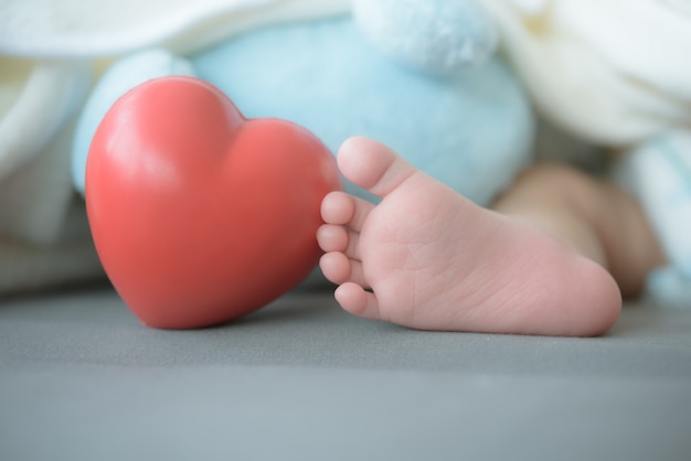 baby's feet with a red heart