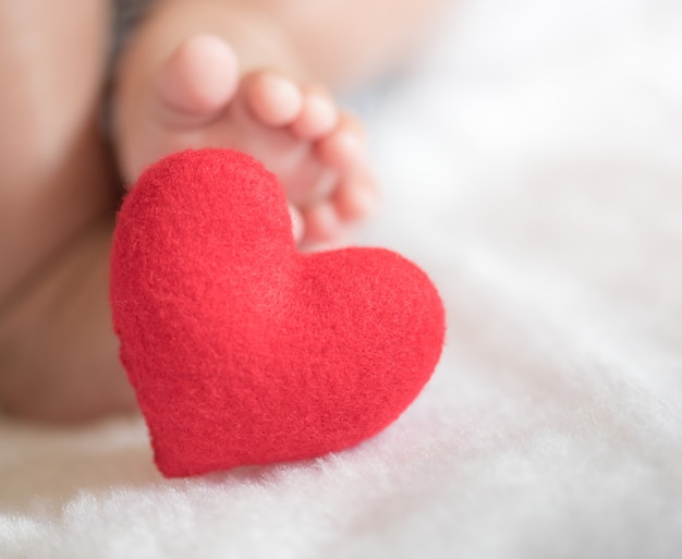 baby's feet with a red heart