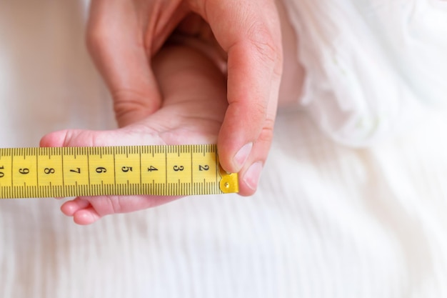 The baby's foot is measured with a measuring tape. choosing the size for shoes