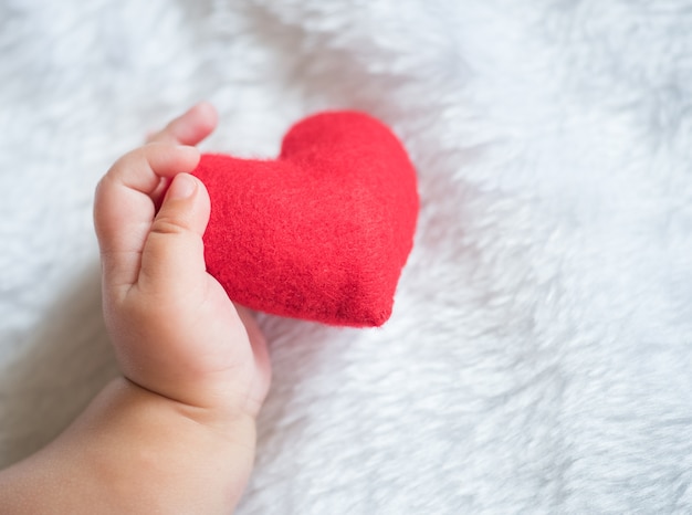 Foto baby's hand met een rood hart