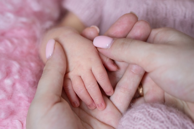 A baby's hand on a woman's palms