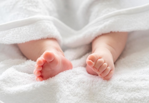 Baby's kleine benen genesteld onder een zachte sluier concept van baby tederheid postbath routine
