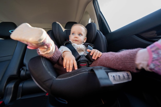 Baby safely seated in car seat for road trip concept of secure travel for children in vehicles