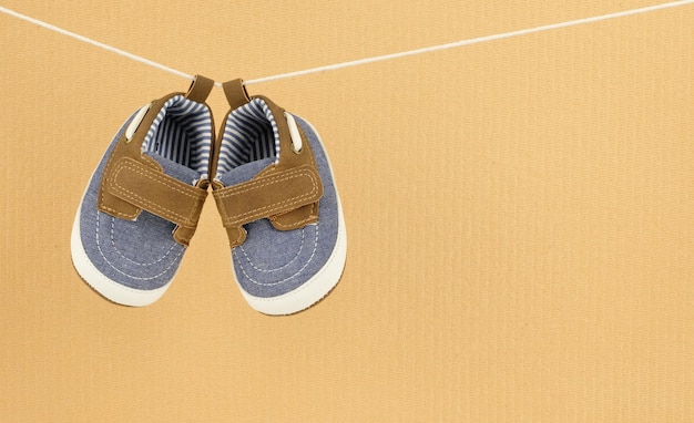 Baby schoenen opknoping geïsoleerd op multiplex achtergrond met kopie ruimte baby kleding concept