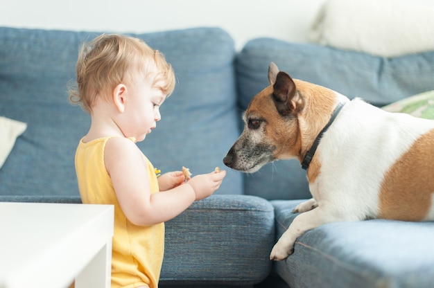 Baby sharing cookie with dog