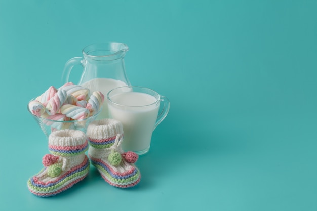 Baby shoes and glass of milk