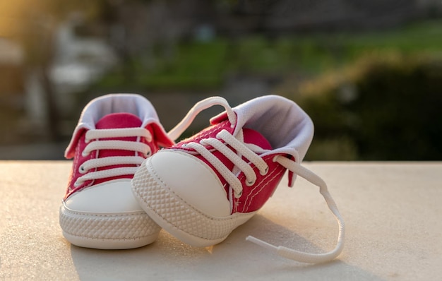 Baby shoes outdoors on blur nature background closeup view