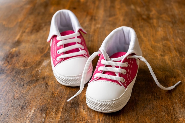 Baby shoes on wood closeup view frpm above