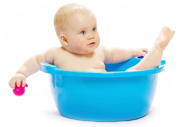 Baby sitting in a blue tub