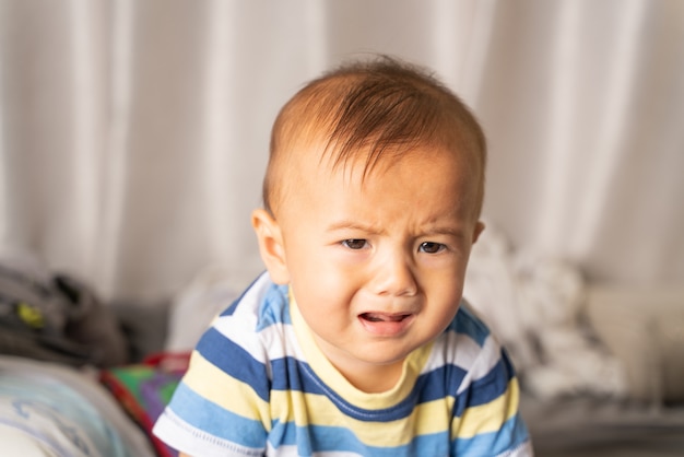 Baby sitting sad and crying in the room