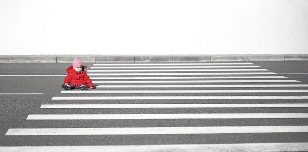baby sitting on zebra crossing against clear sky