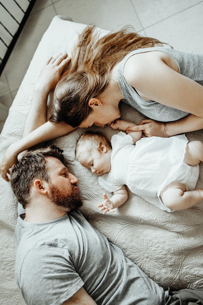 Baby slaapt met papa en mama op het bed. Gelukkige familie thuis.
