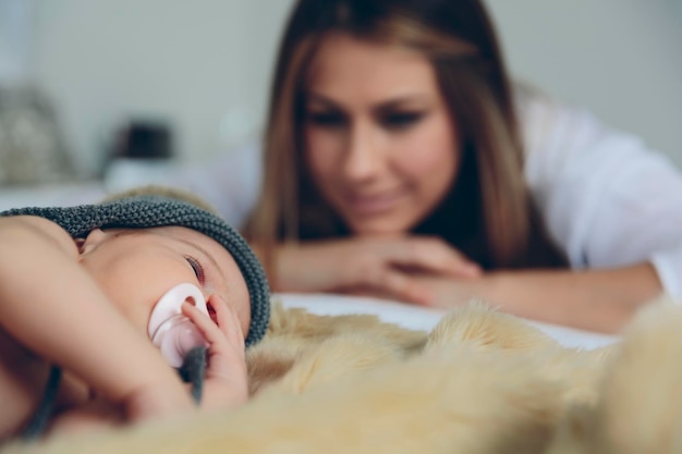 写真 母親が見ている間に毛布で寝ている赤ちゃん