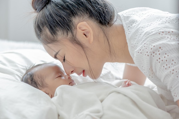 사진 아기는 아시아 어머니를 자고 부드러움과 애정으로 아이를 만집니다