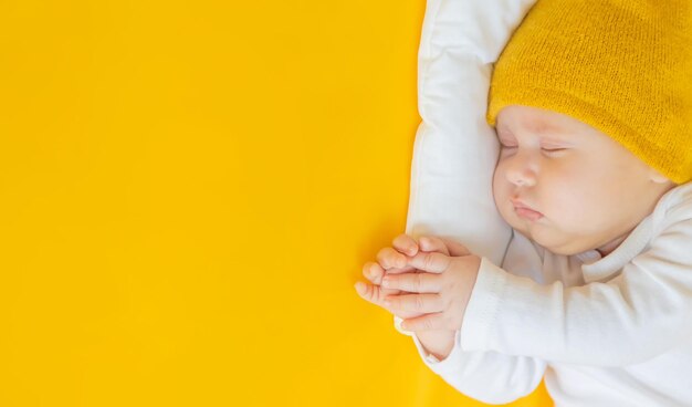 Il bambino dorme su uno sfondo giallo messa a fuoco selettiva