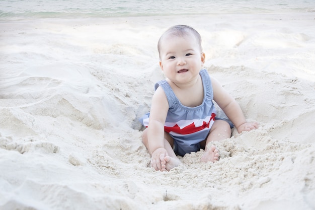 Foto bambino sorridente e seduto su una spiaggia